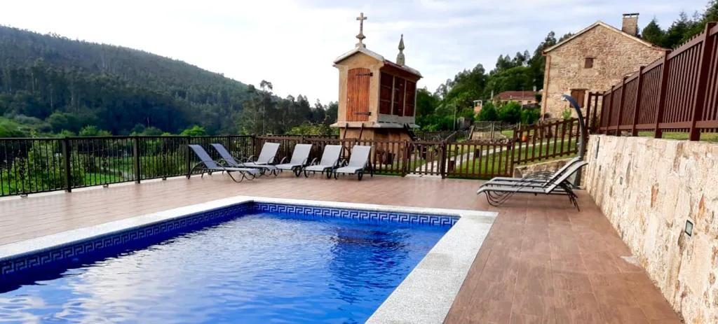 Piscina con vistas a la montaña y hórreo con cruz en la cima, A Avoa María, Campo Lameiro