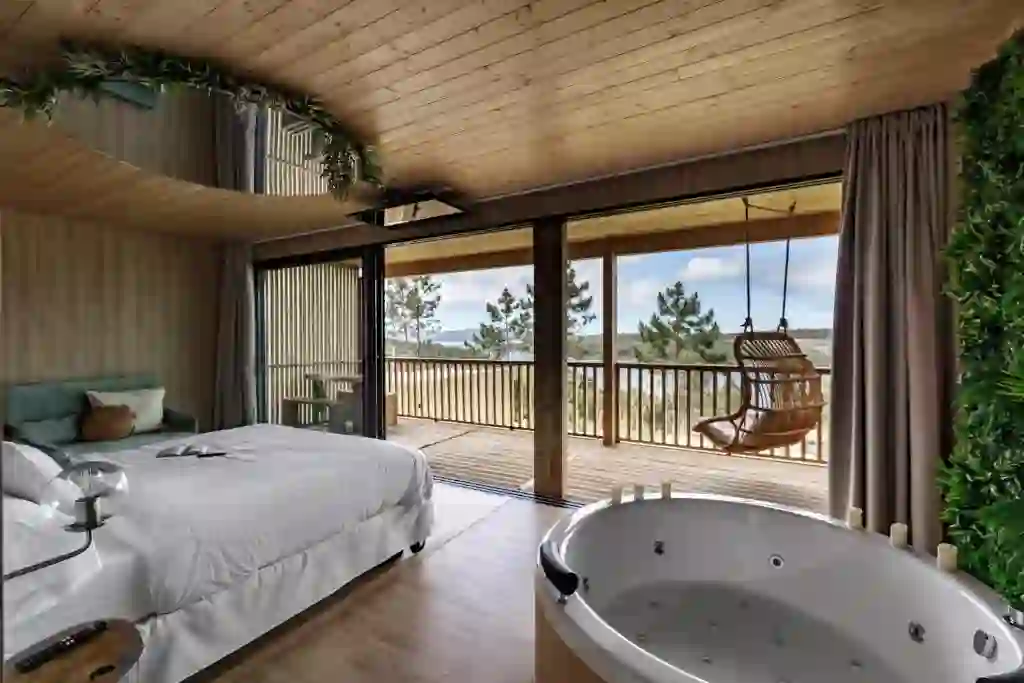 Jacuzzi de hidromasaje frente a la cama con vistas a la ría y balcón de madera, Cabanas da Luz, Camariñas
