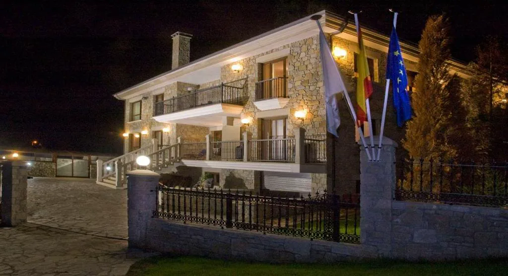 Fachada de piedra iluminada de noche con banderas ondeando, Casa Buda Conors & Spa Boutique, Foz