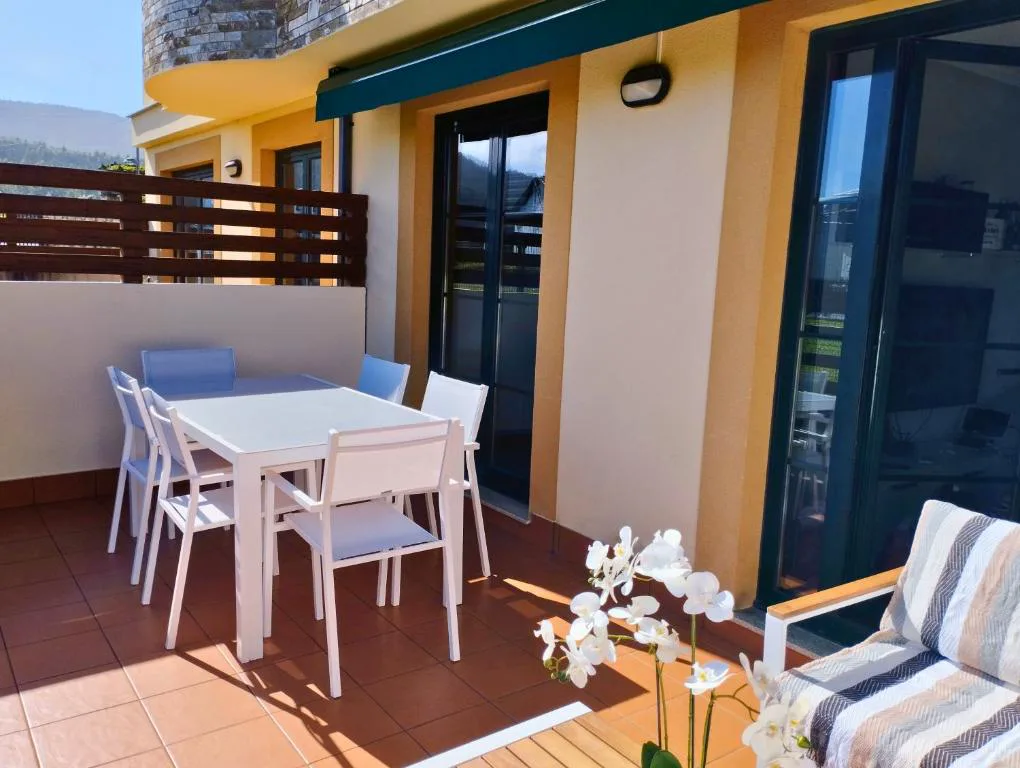 Terraza con mesa de comedor y orquídeas, Costa SPA Terraza de lujo, San Miguel de Reinante