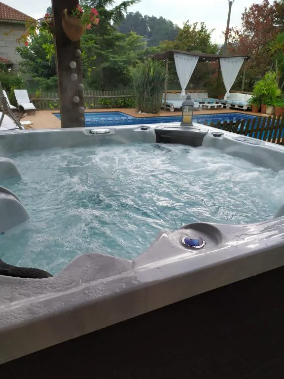 Jacuzzi exterior privado con chorros junto a la piscina y el jardín, El Atico de Villalmar