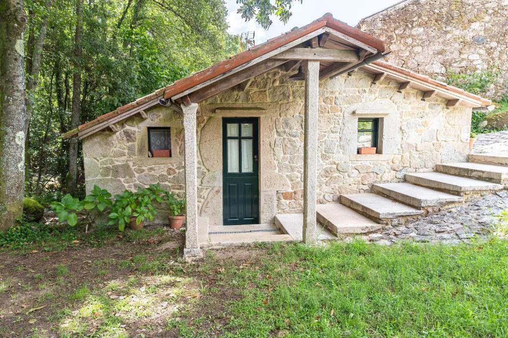 Bañera de madera calentada con leña junto a una casita de árbol en el jardín, Entre Os Ríos