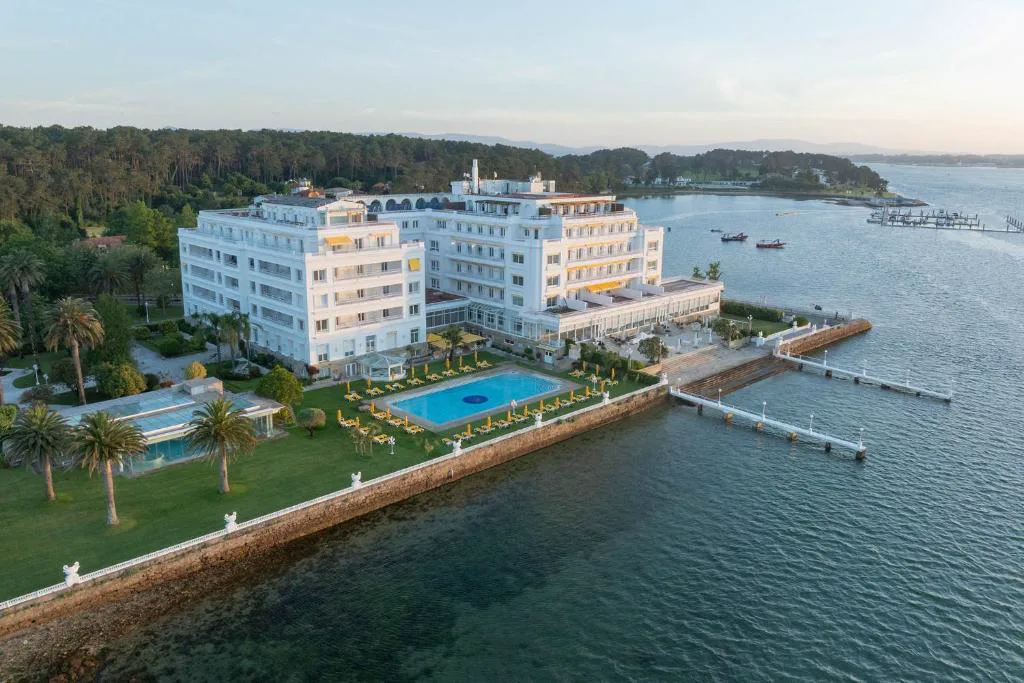 Vista aérea del Gran Hotel La Toja junto a la ría de Arousa, con piscina exterior y embarcadero