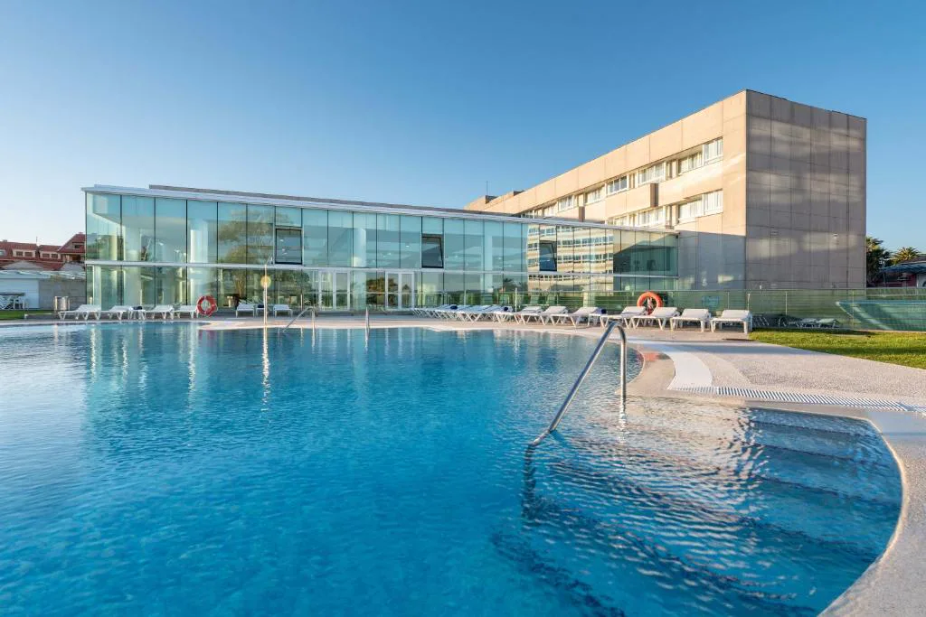 Piscina exterior climatizada junto a la fachada acristalada del Eurostars Isla de La Toja