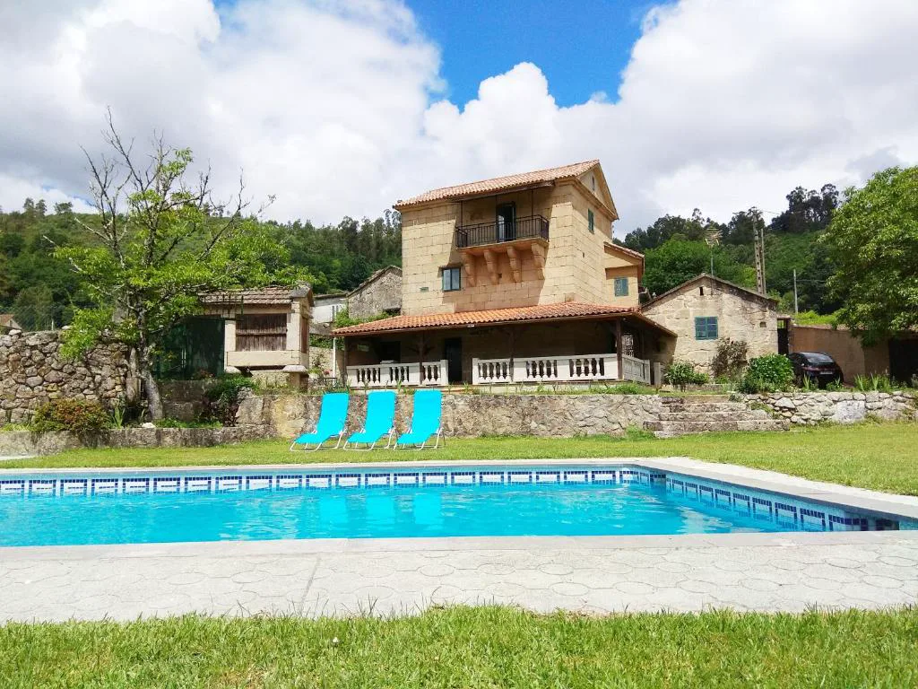 Piscina privada frente a la casa-torre de piedra tradicional, La Torre Mondariz