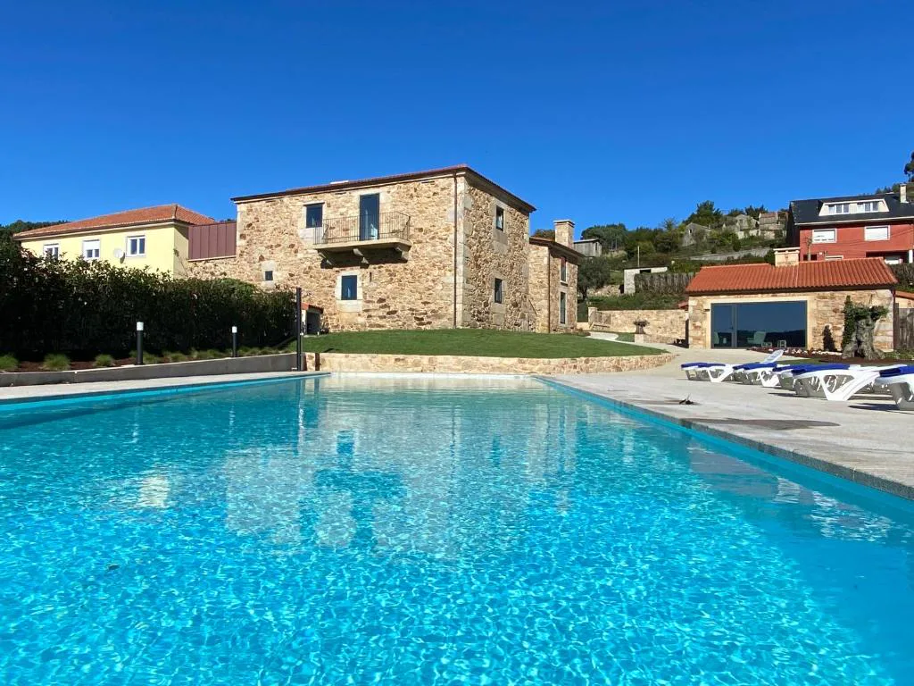 Casa señorial de piedra con gran piscina exterior y tumbonas, Morada Atlántica, Carballo