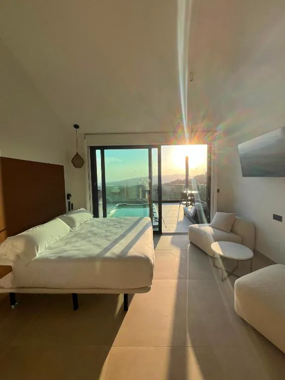 Dormitorio con vistas directas a la piscina privada al atardecer, Nidos de Carnota