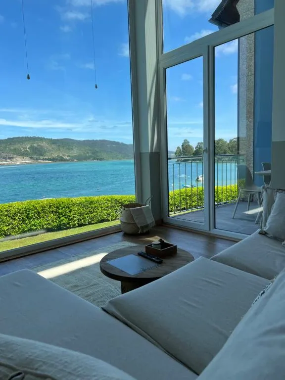 Salón con ventanal panorámico frente a la ría de Anllóns en Porto Cabana by Miramar Stays, Cabana de Bergantiños