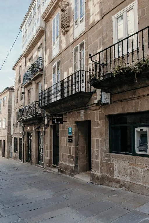 Fachada de piedra con balcones de forja del Via Aetcal Hotel & Wellness, en una calle del casco histórico de Santiago de Compostela